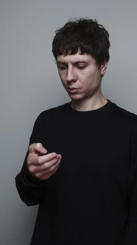 Man scrolling on phone feed feeling anxious and distracted in studio grey Stock Footage 327665757