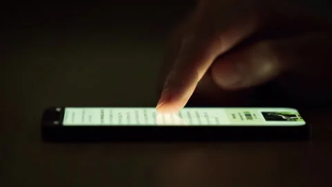 Man Scrolling on Phone Resting on Table, Lit Solely by Device Light Stock Footage 271671318