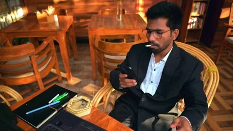 Man Scrolling in Phone While Smoking Stock Footage 281335147