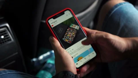 Man scrolling through the Instagram feed while sitting in the car. Moscow Russia Stock Footage 158284202