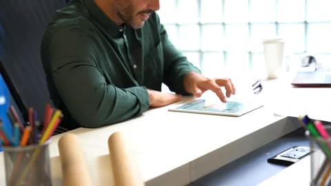 Man scrolling through tablet in modern office space Stock Footage 101321882