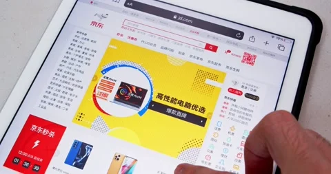 Man scrolls a Chinese B2C e-commerce company JD.com website on tablet 스톡 동영상 167753079
