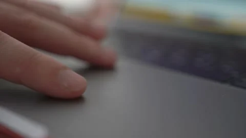A man scrolls his fingers along the track pad of a laptop website page at work Stock Footage 155638485