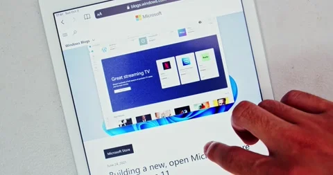 Man scrolls new Microsoft Store on Windows 11 introduction blog post Stock Footage 162164702