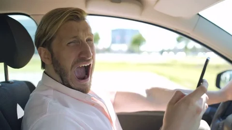 Man scrolls smartphone while in car and yawns Video stock 83613244