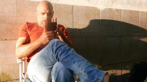 A man scrolls through a smartphone screen. A person checks their smartphone Fotos de archivo