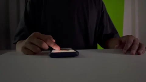 A man scrolls through social media on his smartphone at night Stock Footage 325041704