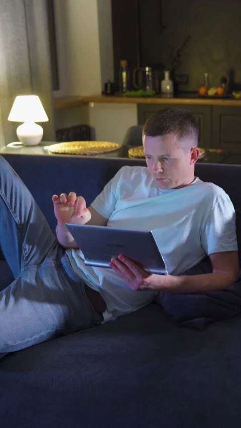 Man, scrolls through social networks, looks at screen of mobile device glowing Stock Footage 314282615