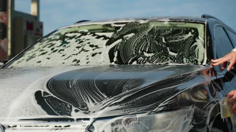 Man Scrubbing Car with Sponge at Self-Service Car Wash Stock Footage 297127945