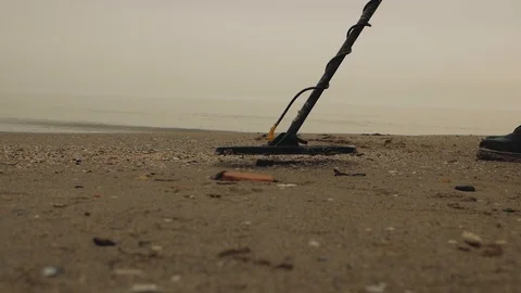 Man by the sea with a metal detector is looking for treasure in the sand Stock Footage 103140850