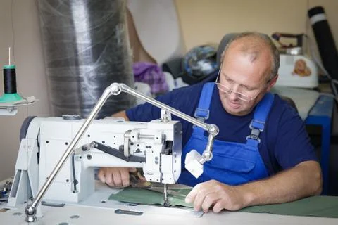 Man seamsrtess sitting at the sewing machine Stock Photos