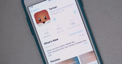 Man searches and watch introduction of Tantan app from App Store on iPhone Stock Footage 154322151