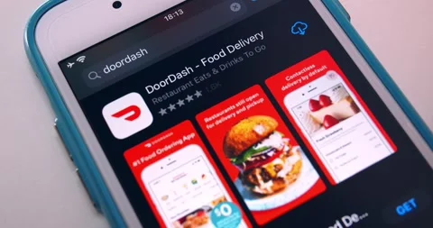 Man searches DoorDash app in App Store and watches its page on iPhone Stock Footage
