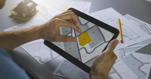 Man searching building plot to buy on cadastral plan for house construction o Fotos de archivo