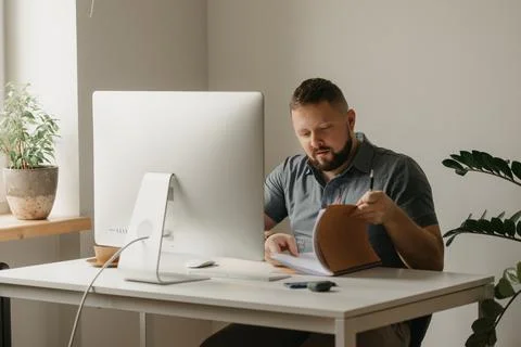 A man is searching for information in a notebook during a video conference Stock Photos