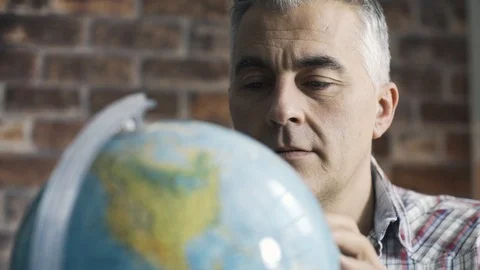 Man searching for a place on a globe Stock Footage 103202725