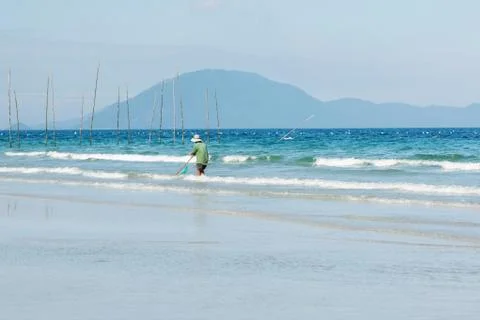 Man searching small shell from the beach Stock Photos