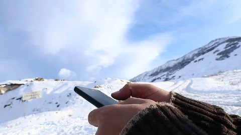 Man searching something on smartphone at mountain peak. Swiping with hand on Stock Footage 85167338
