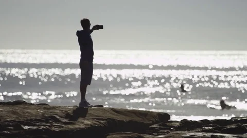 Man on a seashore is taking a picture of marvelous landscape Stock Footage 75748352