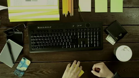 A man seat near a computer keyboard on his desk and removes the card under the Stock Footage 82010915