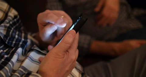 Man seated alongside a friend using his mobile phone Stock Footage 152891864