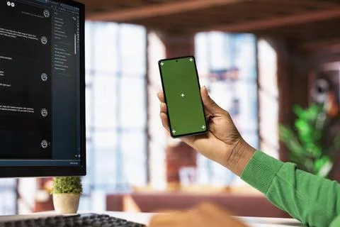 Man seated at desk using AI LLM chatbot software on PC and mockup phone Stock Photos