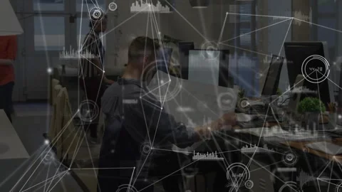 Man seated reading paper while woman coming pointing at monitor for tech review, Stock Footage 329812949