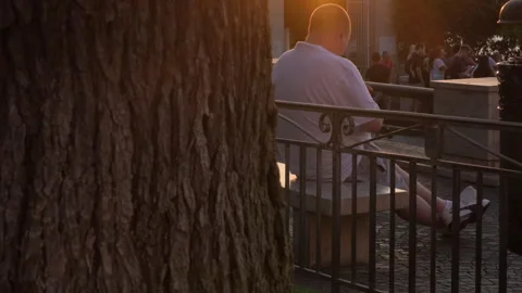 Man seating on a bench enjoying the sunset in Sorrento, on a sunny summer day Video stock 248535783