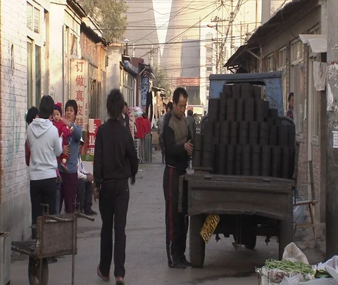 Man secures coal bricks in bed of three-wheeled truck Stock Footage 86745488