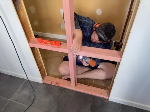 Man securing timber wall framing pieces with a power tool Stock Photos