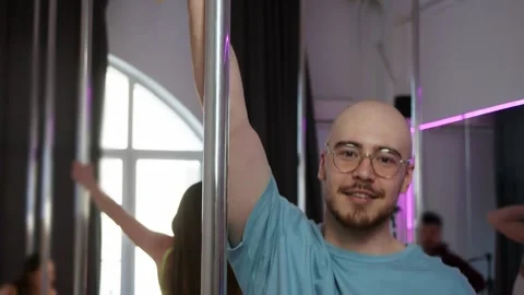 A man seductively performs a dance at the pole during a pole dancing class Stock Footage 305091202