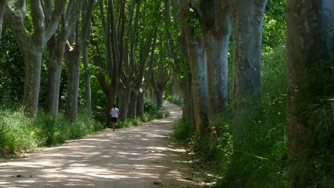 A man seen from behind running by the mountain road.Camera Movement Dolly in. Stock Footage 75786489