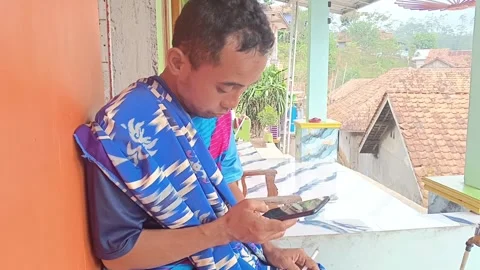 A man is seen playing a mobile game or using a social Stock Footage 315308428