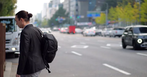 Man sees that cab is not coming, returns to sidewalk, slow motion, blurred back Stock Footage 303987803