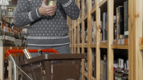 Man selecting a bottle of wine for his shopping cart Stock Footage 311950169
