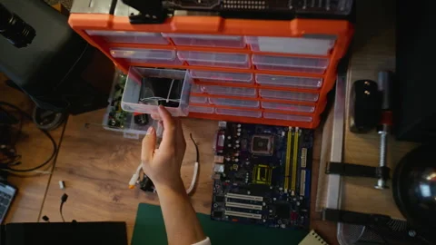 Man Selecting Computer Hardware Components from Organizer Drawer Stockbeeldmateriaal 338423941