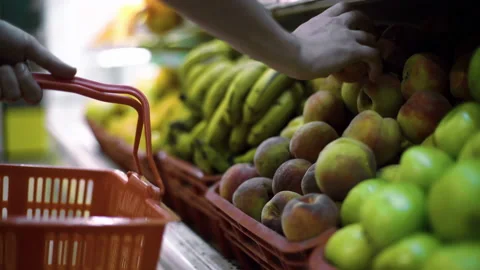 Man selecting fresh peach at grocery store supermarket sale, taking food at mark Vidéo 168930007