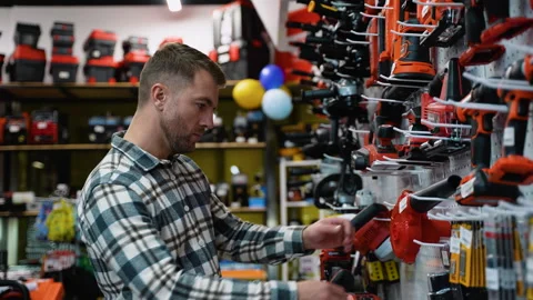 A Man Selecting a Leaf Blower in a Hardware Store Stock Footage 295969996
