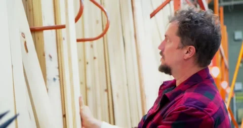 Man Selecting Lumber in a Hardware Store Aisle Stock Footage 323779106