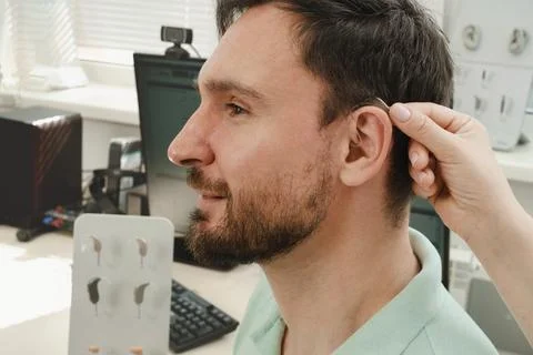 Man selecting modern compact hearing aids Stock Photos
