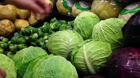 Man selecting savoy cabbage in grocery store Stock Footage 52706229