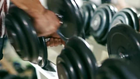 Man Selecting Weights from Dumbbell Rack in Gym Essential Equipment for Ath.. Stock Footage 256750268