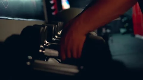 Man Selecting Weights from Dumbbell Rack in Gym Essential Equipment for Heavy Stock Footage 256751234