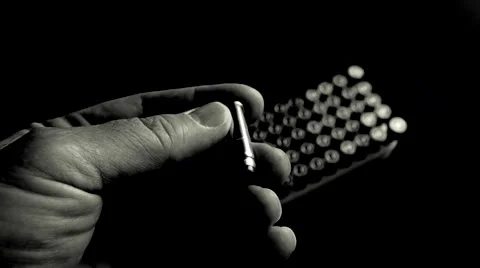 Man selects a .357 caliber pistol bullet. (b/w) Stockbeeldmateriaal 61716220