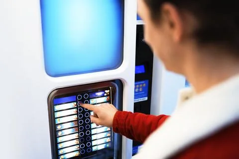 A man selects a drink from a modern self service coffee machine. 스톡 사진