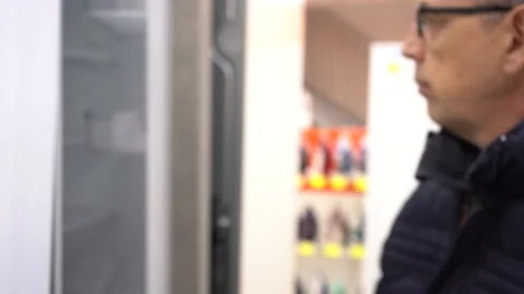 A man selects a new washing machine at the Appliance Store. Stock Footage 151772903