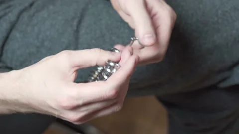 A man selects the size of the wedding ring using the Ring Size Tool. Stock Footage 153548270