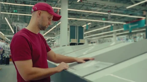 Man selects tile with care in home improvement store during afternoon shopping Stock Footage 293672846