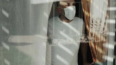 Man in self isolation looking out of the window Stock Footage 138901697