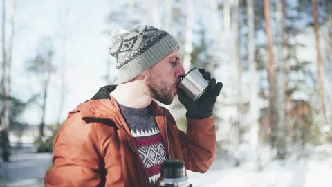 Man in self-isolation. A man drinking hot tea in winter forest. Relaxing aftter Stock Footage 128453931